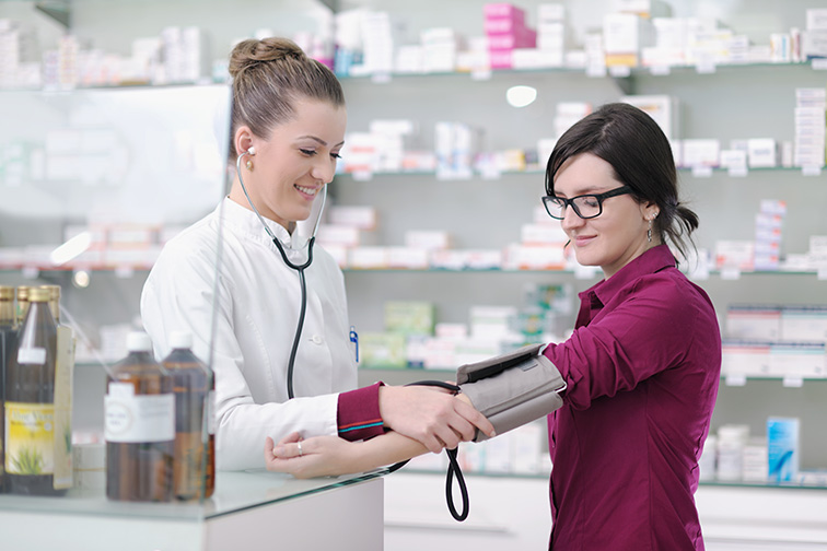 doctor checking blood pressure and heart rate in a hospital or in pharmacy with young female patient